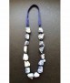 Necklace of irregular knotted lapis lazuli stones with knitted ribbon.